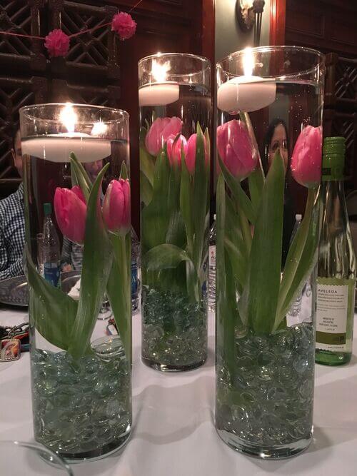 tulips and floating candles in cylinder vases